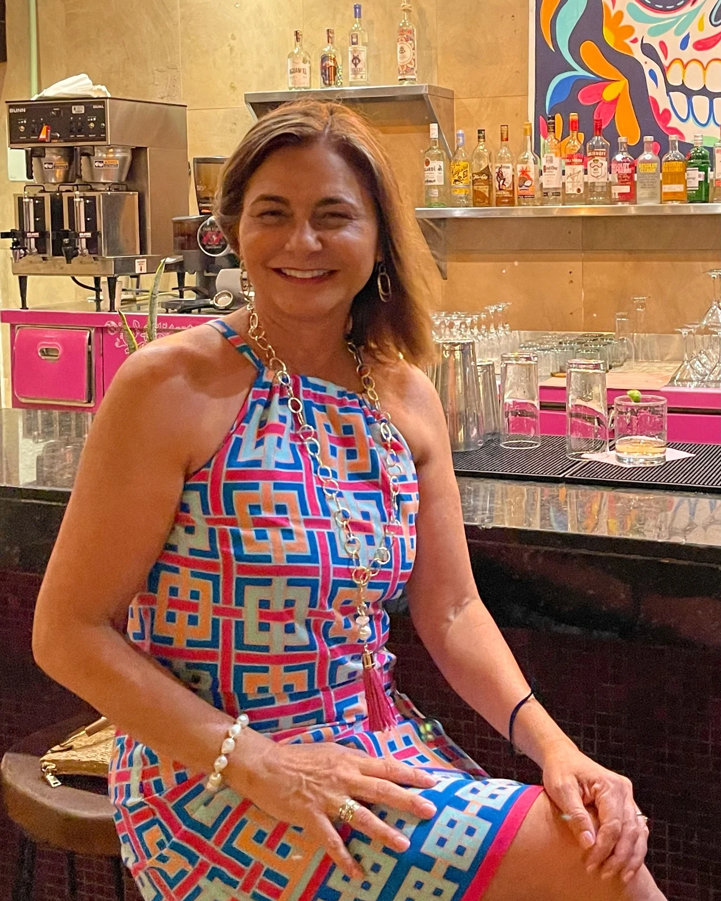 Toni, the designer behind Mandari, wearing jewelry with a colorful dress